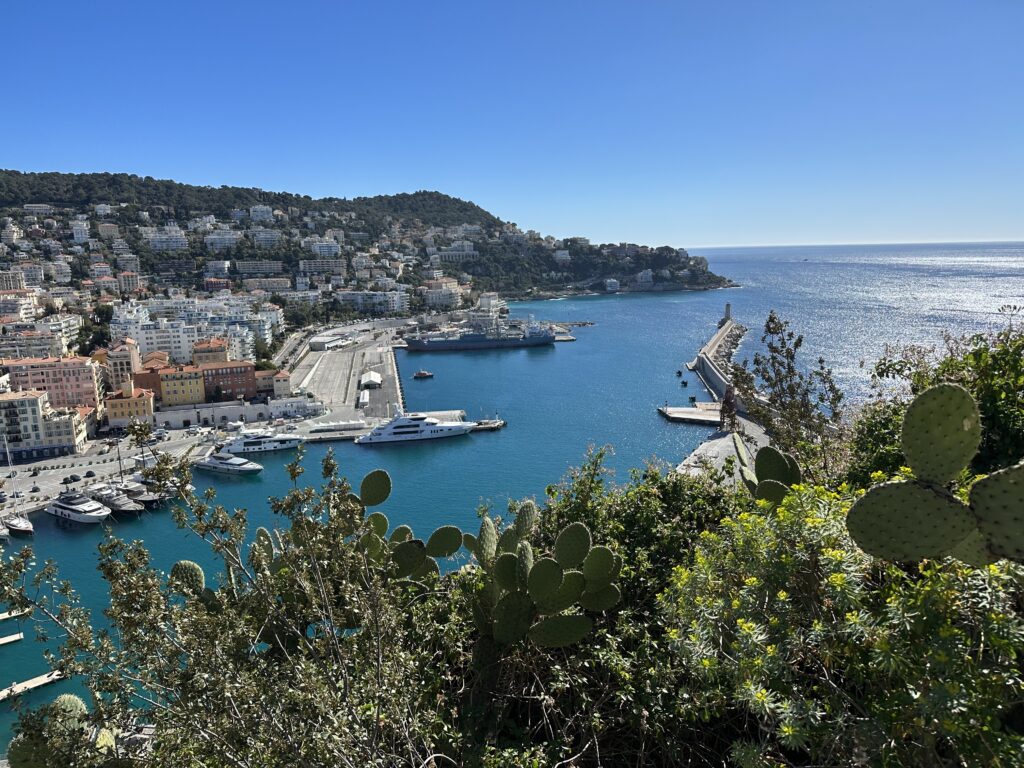 "Panoramic view of Nice, France Port, from the top of Castle Hill, showing the Mediterranean coastline, the Promenade des Anglais, and the city's historic buildings."